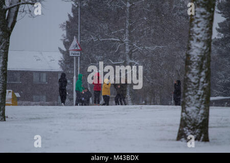 Dundee, Schottland, Großbritannien. 14. Februar, 2018. UK Wetter: Starker Schneefall in Nordostschottland mit Temperaturen nahe dem Gefrierpunkt. Schule Kinder, die in der winterlichen Bedingungen um Arldler Dorf während Ihrer Mittagspause. Credits: Dundee Photographics/Alamy leben Nachrichten Stockfoto