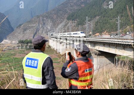 Chongqing, China. 30 Jan, 2018. Bahn Wartung Arbeiter Liao Xiaocheng (L) und seine Frau Tao Chunxiu watch ein High-speed-Bahn, die durch eine Brücke im Dorf Lyuchunba Sanjian Stadt in Fengdu Grafschaft von Chongqing, Südwesten, China, Jan. 30, 2018. Der 50-jährige Liao und seine Frau Tao Chunxiu, sowohl Bahn Wartung Arbeiter der Chongqing-Lichuan Lyuchunba Abschnitt der Bahnlinie, sind verantwortlich für die Sicherheit der 6 km langen teilstrecke hier. Credit: Tang Yi/Xinhua/Alamy leben Nachrichten Stockfoto