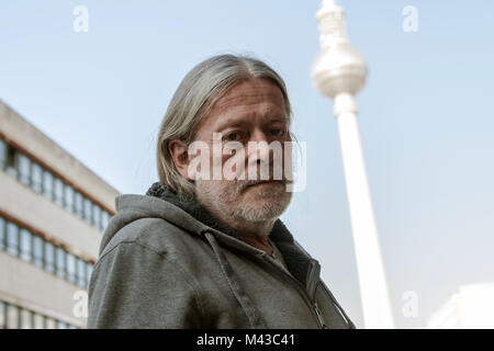 Berlin, Deutschland. 14 Feb, 2018. Fotograf Harald Hauswald, die eine Zigarette Pause während einer Pressekonferenz zu seiner Ausstellung "Völlig Osten. Das Leben in der DDR" in Berlin, Deutschland, 14. Februar 2018. Berliner Fernsehturm im Hintergrund gesehen werden. Credit: Paul Zinken/dpa/ZB/dpa/Alamy leben Nachrichten Stockfoto