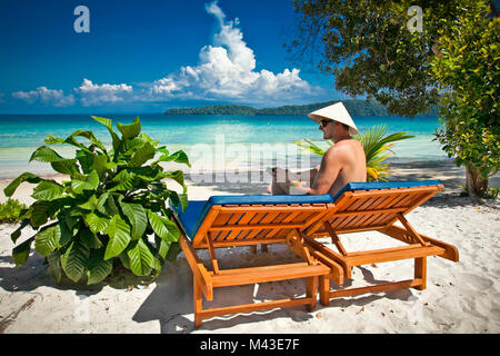 Mann, der an einem tropischen Strand auf Koh Rong Samloem Insel in Kambodscha. Stockfoto