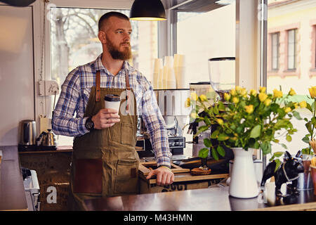 Redheads Handwerk/Verkäufer in einem kleinen Straßencafe. Stockfoto