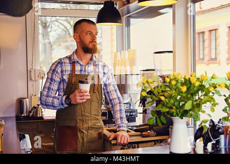 Redheads Handwerk/Verkäufer in einem kleinen Straßencafe. Stockfoto