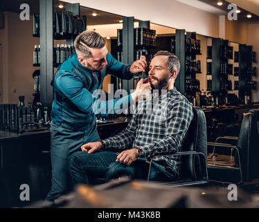 Stilvolle Friseur grooming Bart eines Mannes in einer Limousine. Stockfoto