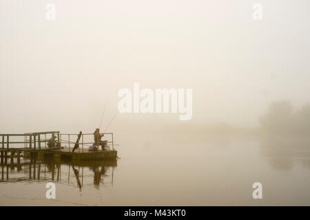 TEXT HIER EIN Mann angeln im Fluss am frühen Morgen Nebel. Stockfoto
