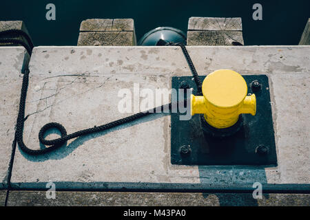 Gelbe Liegeplatz Poller am Pier mit Liegeplatz Seile Stockfoto