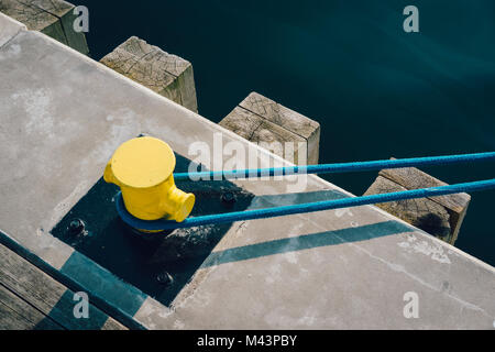 Gelbe Liegeplatz Poller am Pier mit Liegeplatz Seil Stockfoto