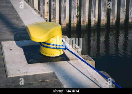 Gelbe Liegeplatz Poller am Pier mit Liegeplatz Seil Stockfoto