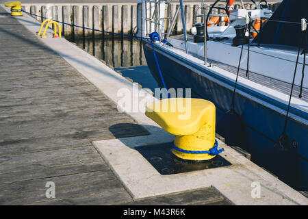 Liegeplatz Poller auf einen Holzsteg mit angedockten Yacht auf dem Hintergrund Stockfoto