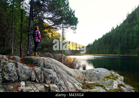 Weibliche Touristen Brohm See im Winter in der Nähe von Whistler, BC Kanada und entspannt sich in der schönen Landschaft Stockfoto