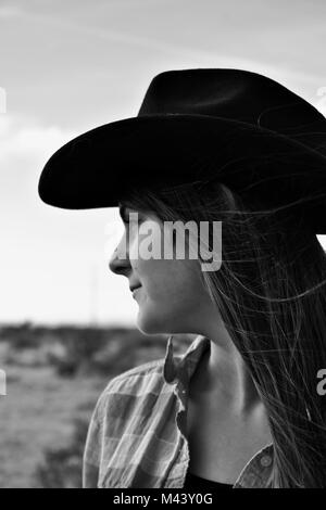 Mädchen in Cowgirl Hut suchen Sie in eine Wüste Feld, Schwarzweiß Stockfoto