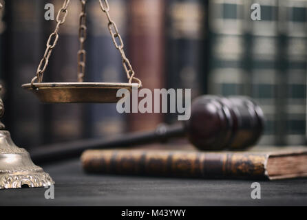 Recht und Gerechtigkeit, Rechtmäßigkeit Konzept, Waage der Gerechtigkeit und Richter Hammer auf einem schwarzen Holz- Hintergrund. Stockfoto