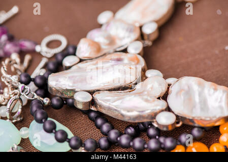 Biwa Perlenkette Verlegung auf natürliche braune Bettwäsche Tischdecke. Black Onyx und Achat Edelsteine herum. Heilung, kraftvolle Energie für Crystal Therapie behandeln Stockfoto