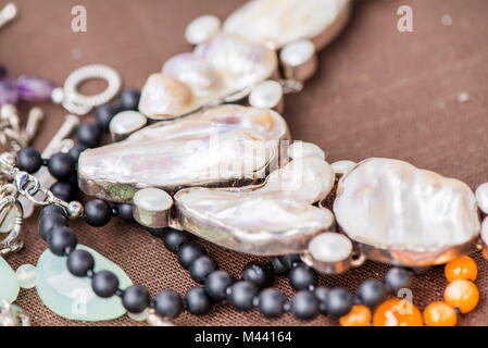 Biwa Perlenkette Verlegung auf natürliche braune Bettwäsche Tischdecke. Black Onyx und Achat Edelsteine herum. Heilung, kraftvolle Energie für Crystal Therapie behandeln Stockfoto