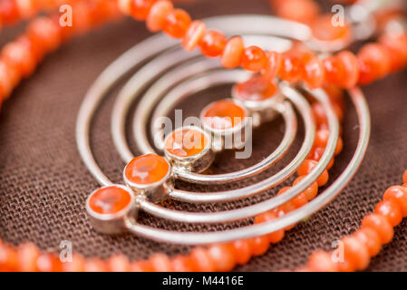 Serdolik (Karneol) Stein Kette Verlegung auf natürliche braune Bettwäsche Tischdecke. Yashma, orange Jaspis, Onyx Edelsteine herum. Heilung, kraftvolle Energie f Stockfoto