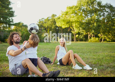 Familie spielen mit einem Ball im Park. Stockfoto
