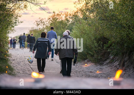 Romantische Lagerfeuer Nacht am Meer bei Sonnenuntergang. Leute versammeln um Nacht der alten Leuchten feiern. Alte Paar Stockfoto