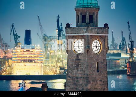 Industrielle Skyline bei Nacht. Historische Clock Tower im Hafen in Hamburg. Stockfoto