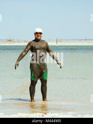 Mann nimmt ein Schlammbad in der salzigen See Baskunchak Stockfoto