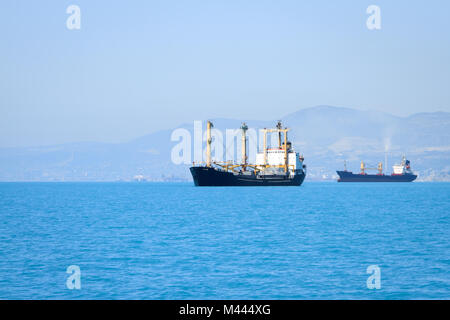 Segeln in stilles Wasser in der Nähe von Port Frachtschiff Stockfoto