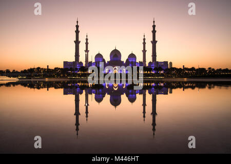 Sheikh Zayed Grand Moschee und es ist perfekt Reflexion in einem Pool mit Wasser während der Dämmerung nach Sonnenuntergang. Abu Dhabi, VAE. Stockfoto