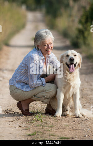 Portrait der älteren Frau, kauern neben Hund Stockfoto