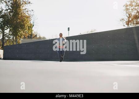 Kurvenreiche junge Läuferin in städtischen Einstellung läuft Stockfoto