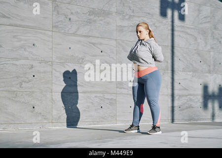 Kurvenreiche junge Frau training, Stretching Arms Stockfoto