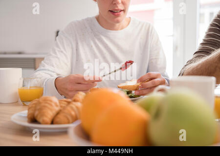 7/8 shot der jungen Frau und Freund in Croissants zum Frühstück Tabelle Stockfoto