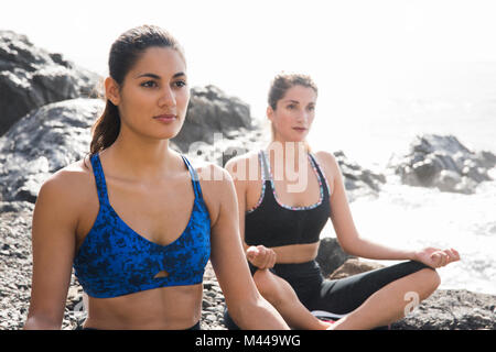 Zwei junge Frauen üben Yoga lotus Stellen am Strand, Las Palmas, Kanarische Inseln, Spanien Stockfoto