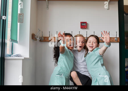 Drei Schülerinnen Spaß in der Grundschule Garderobe Stockfoto