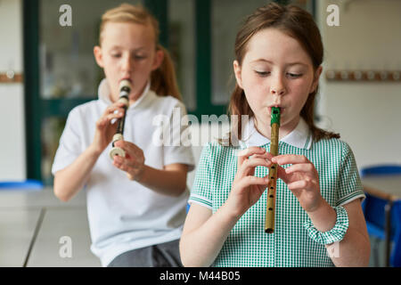 Schülerinnen spielen Recorder im Unterricht in der Grundschule Stockfoto