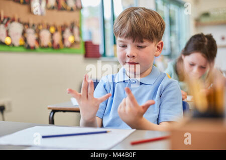 Schüler zählen mit den Fingern in Klassenzimmer Unterricht in der Grundschule Stockfoto