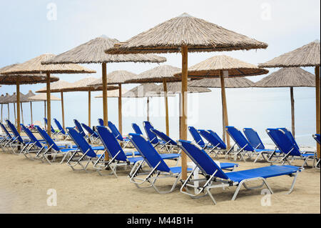 Reed-Sonnenschirme und Liegestühle am Strand Stockfoto