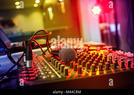 Detail einer Sound Mixer mit einem Mikrofon und einen Laptop mit einem Club Atmosphäre. Stockfoto