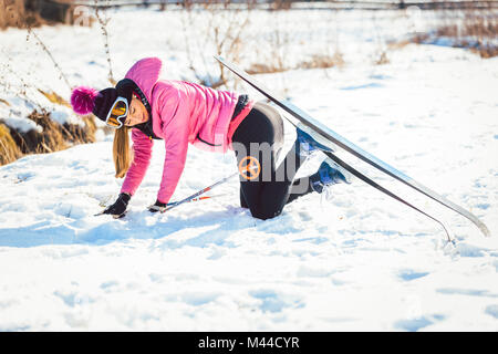 Frau Sturz beim Langlauf tun Stockfoto