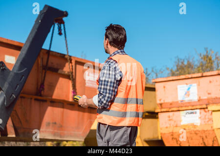 Arbeiter auf der Baustelle entladen Container für Abfälle aus t Stockfoto