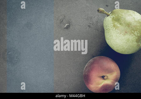 Frische reife Früchte der Saison auf einen Stein Oberfläche - Birne und Pfirsich Stockfoto