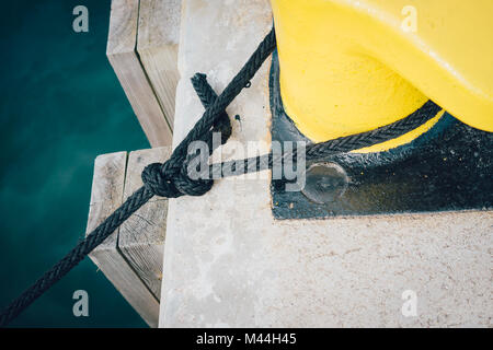 Festmacher Seil um einen Poller auf einem Pier gebunden Stockfoto