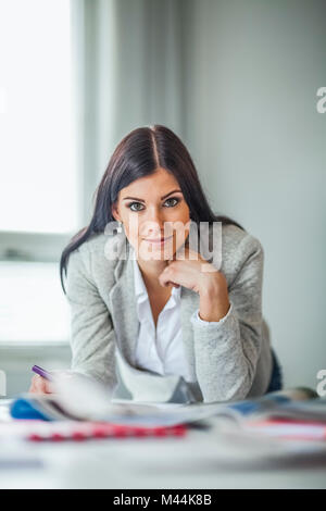 Portrait von schönen jungen Frauen Mode Designer am Schreibtisch im Büro Stockfoto