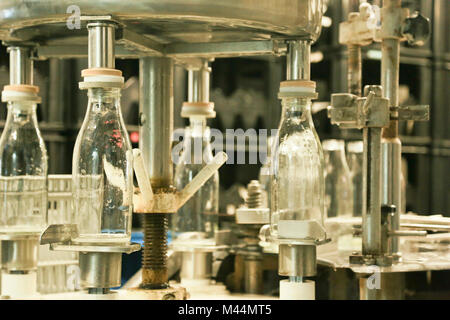 Rolde, Niederlande - Januar 28, 2014: Close-up von Milch Abfüllanlage, vier leere Flaschen drehen um. Selektive konzentrieren. Stockfoto