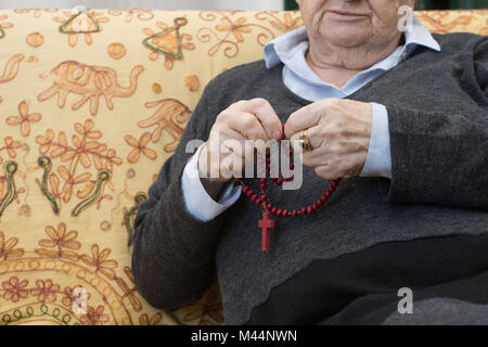 Ältere Frau Hände sagen, beten den Rosenkranz, Christentum religion Lifestyle close up Stockfoto