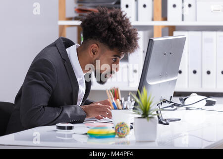 Seitenansicht eines Junge Unternehmer Arbeiten am Computer im Büro Stockfoto