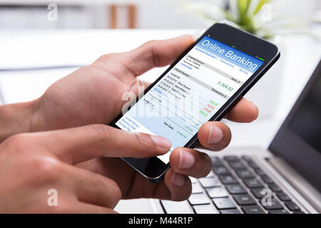 Nahaufnahme der Kaufmann Hand tun, Online Banking auf dem Smartphone am Arbeitsplatz Stockfoto