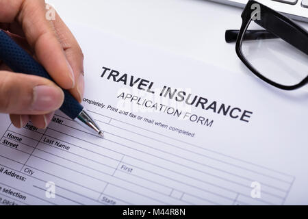 Nahaufnahme von einer Person Hand ausfüllen Reiseversicherung Form Stockfoto