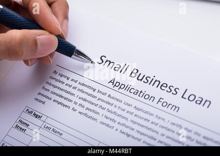 Nahaufnahme der Kaufmann Hand Befüllen Small Business Loan Application Form Stockfoto