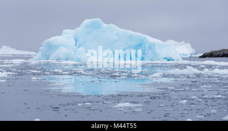 Türkis und Hellblau Eisberg floating in Cierva Cove, die Antarktis in den dunkelgrauen Wasser des Südlichen Ozeans. Stockfoto