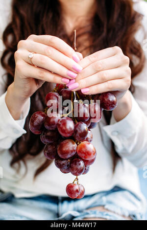 Mädchen, dass eine große Menge von roten Trauben in den Händen. Stockfoto