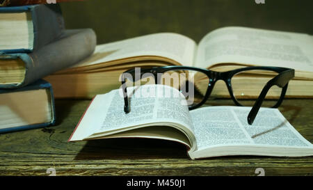 Offene Bibel mit Brille auf die alte Tabelle. Stockfoto