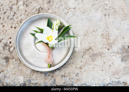 Knopfloch für den Bräutigam auf dem grauen Beton Hintergrund. Nahaufnahme Stockfoto