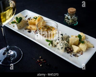 Käseplatte mit verschiedenen Sorten Käse mit Honig, Minze und Muttern Stockfoto